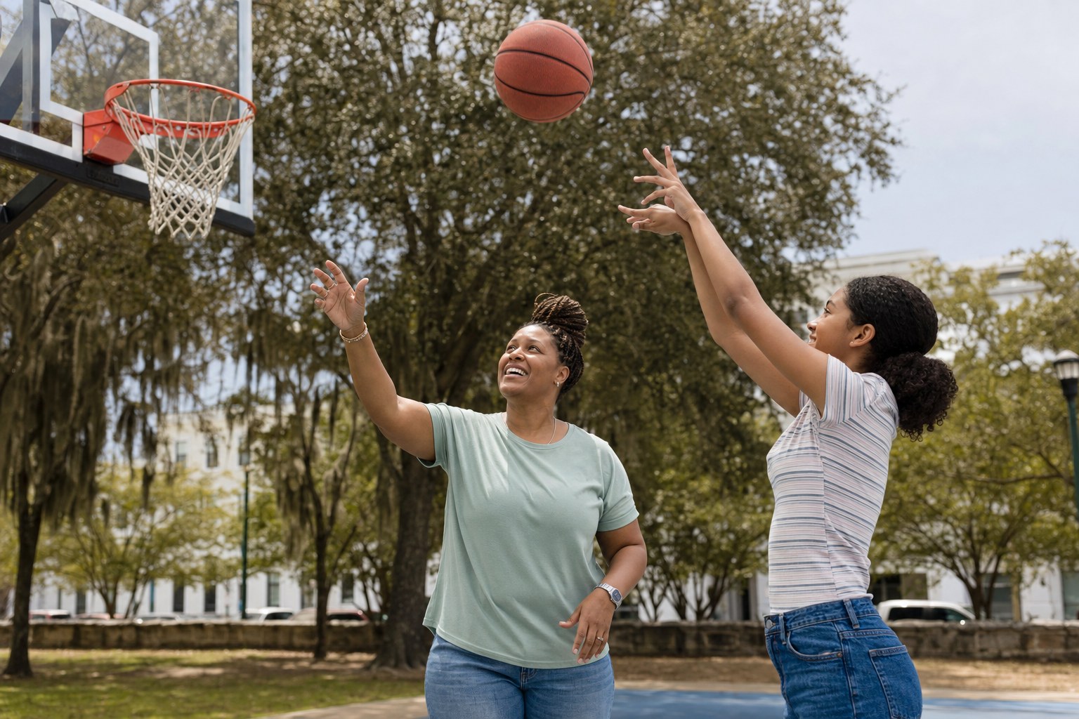 A mentor and young person playing basketball together